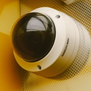 Caméra de surveillance extérieure PoE Hikvision fixée à un poteau sous un ciel bleu