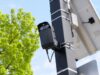 Caméra de surveillance extérieure avec panneau solaire sur mât, ciel bleu