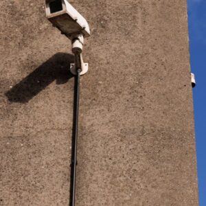 Caméra de surveillance extérieure solaire sans fil installée sur un mur en béton sous un ciel bleu
