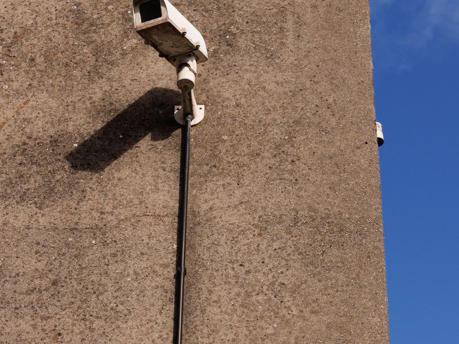 Caméra de surveillance extérieure solaire sans fil installée sur un mur en béton sous un ciel bleu