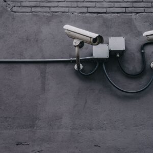 Deux caméras de surveillance grises montées sur mur en béton