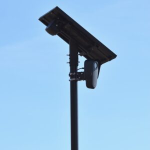 Caméra de surveillance extérieure solaire fixée sur un mât contre un ciel bleu