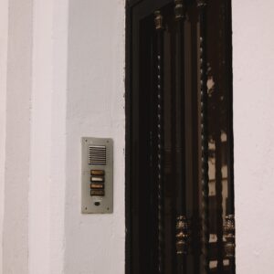 Système d'interphone mural sur la façade d'une maison résidentielle avec porte en fer noir
