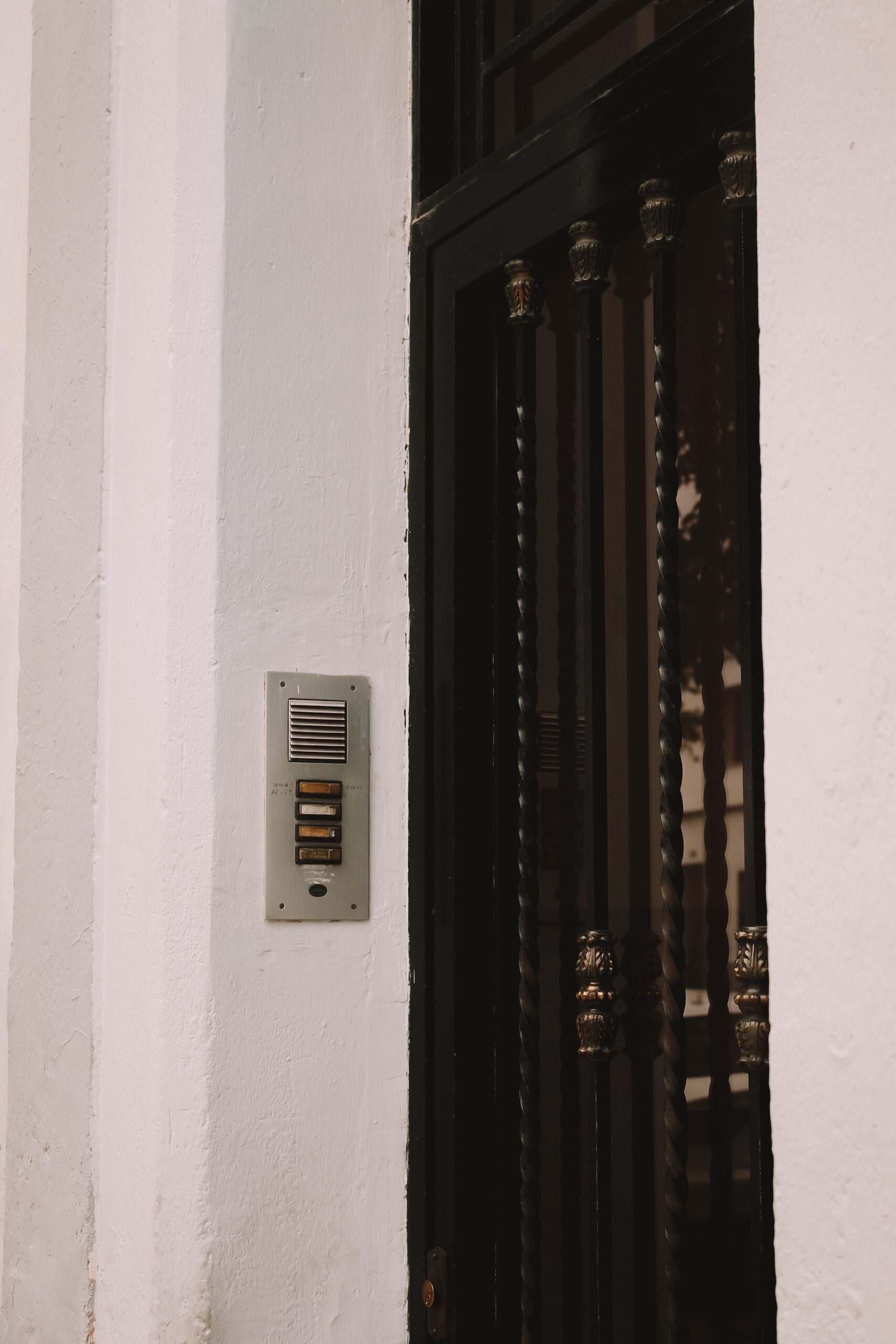Système d'interphone mural sur la façade d'une maison résidentielle avec porte en fer noir