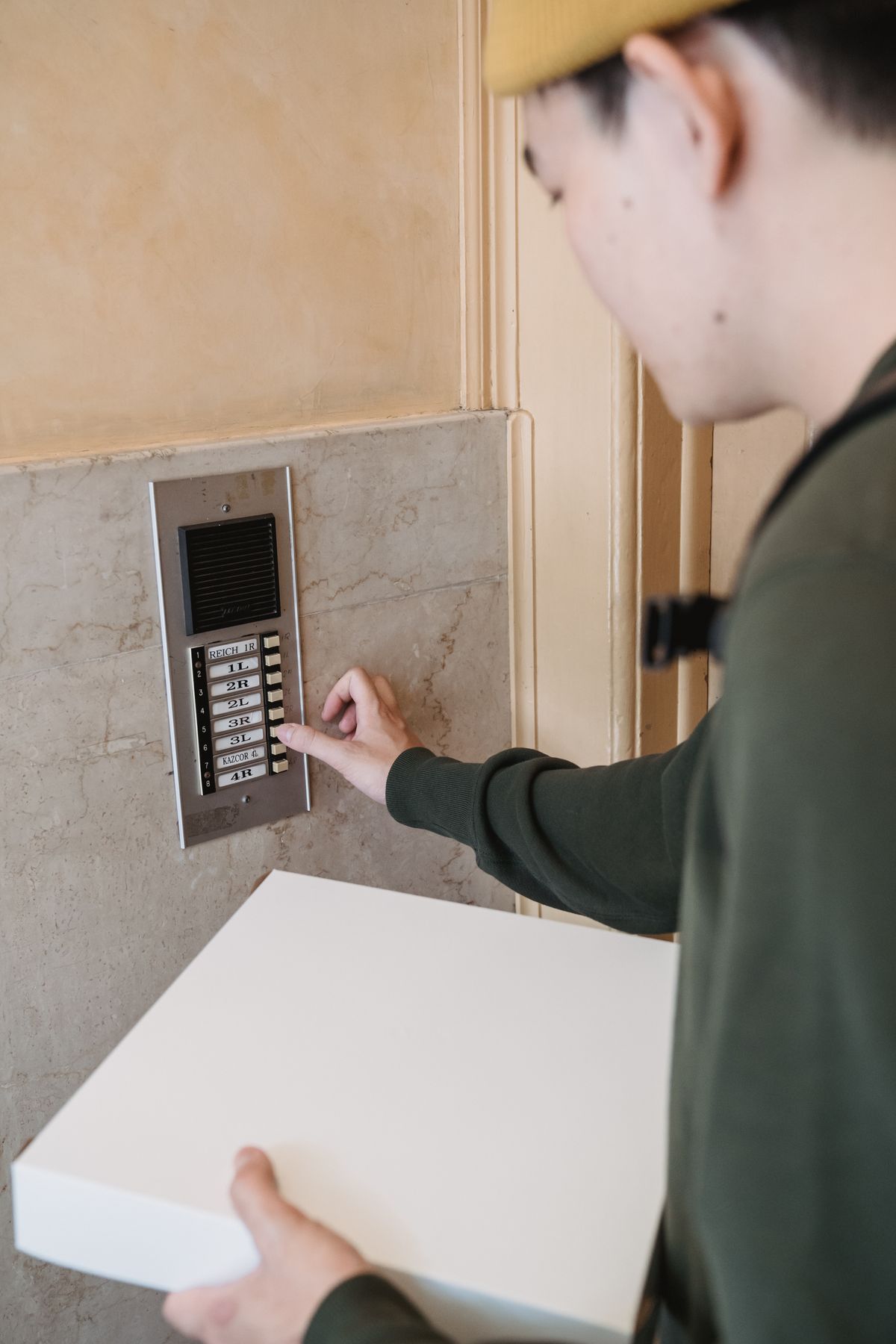 Frais porteur appuyant sur la sonnette vidéo à une maison — modèle Reolink