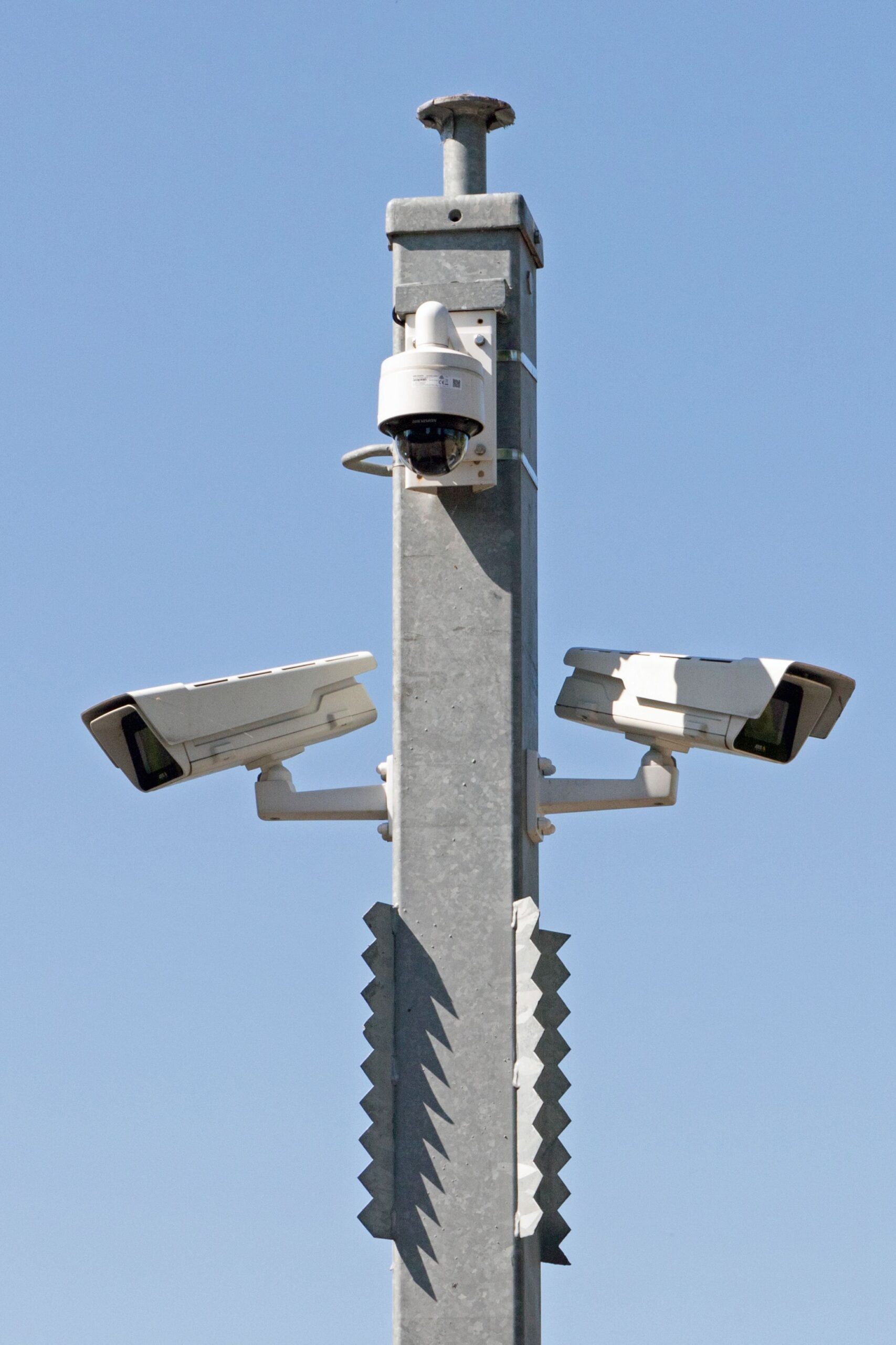 Système de vidéosurveillance extérieur avec plusieurs caméras fixées sur un mât métallique sous un ciel bleu